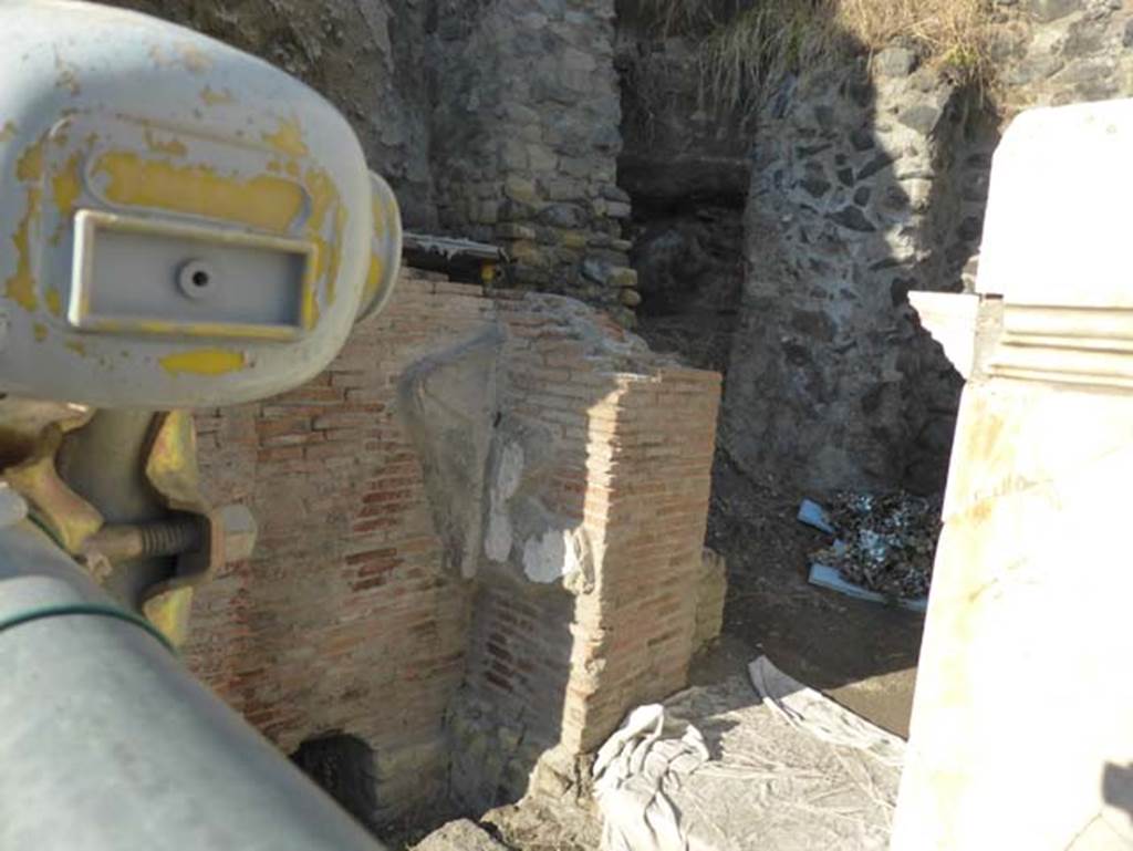 Herculaneum, September 2015. Looking north-west towards west side of the front of the Augusteum, still unexcavated. In this unexcavated area, a second symmetrical arch to the already excavated four-sided arch on the east side, would have been seen.
It is expected to be located opposite the main entrance to the Basilica Noniana. 
According to Kraus and von Matt, - West of the arch, the recent excavations have laid bare a row of brick piers which are reinforced by pilasters at the corners and were formerly faced with marble. These supported stuccoed arcades. Like the arch, this elegant construction on grounds of technique and style, can be dated to about 62AD and seems to correspond to what one finds on eighteenth century plans and drawings which located at this spot a five-gated entrance to the so-called Basilica, a building explored by Alcubierre and Weber only though tunnels.
Kraus T. and von Matt L., 1975. Pompeii and Herculaneum: Living cities of the dead. New York: Abrams. (p.120)